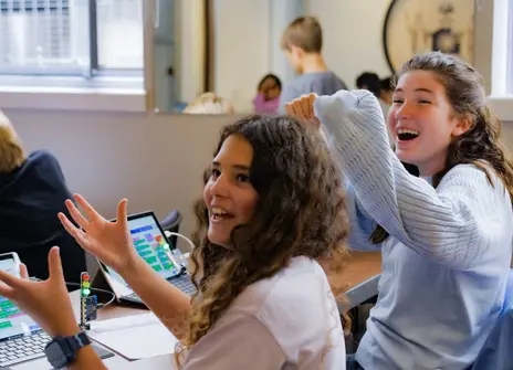 Two girls celebrate as they code a set of traffic lights