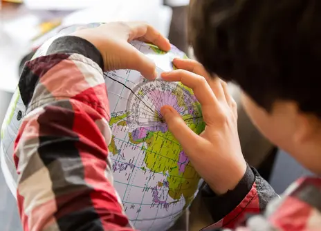 A boy looks at a globe