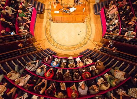 a lecture theatre from above, the seats are curved around a central round stage like an old operating theatre
