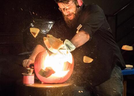 A man conducts demonstration in which a bright light comes out of a larger beaker 