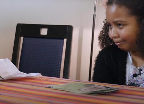 young girl looks at a diaper in disgust