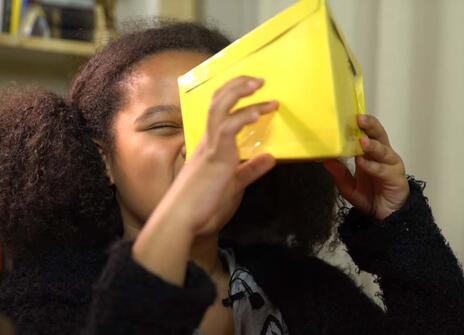 a girl looking into a cardboard box