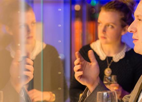 three people looking at something through a display cabinet