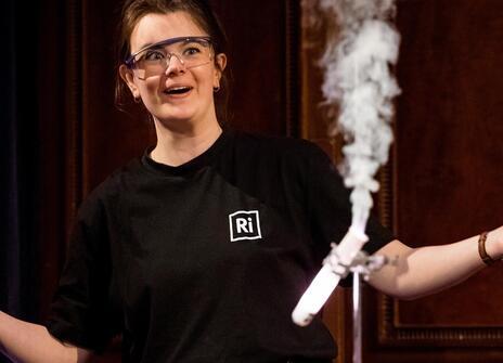 a woman with her arms spread wide and and a test tube with smoke coming out of it