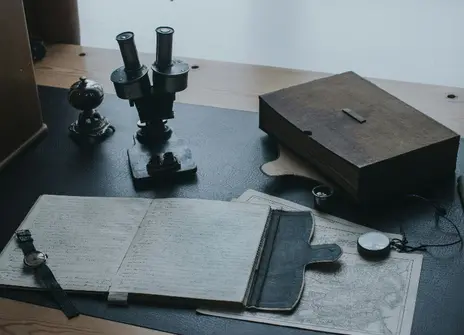 A desk with a journal, box and papers