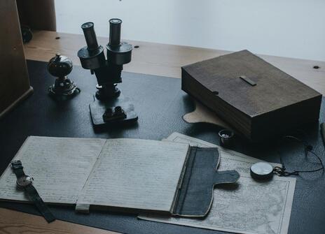 A desk with a journal, box and papers