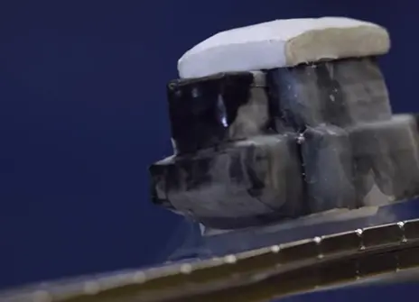 small metal box like object floating above a magnetised track
