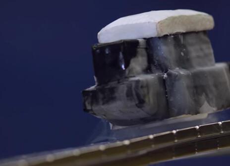 small metal box like object floating above a magnetised track