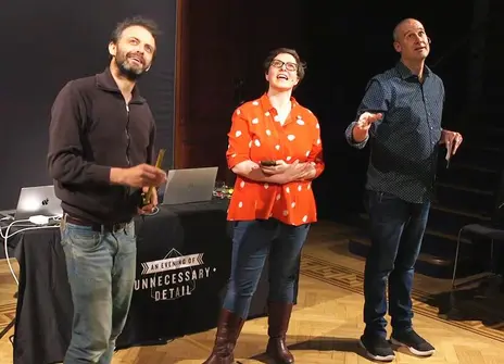 Three people standing in front of Faraday desk in Ri Theatre