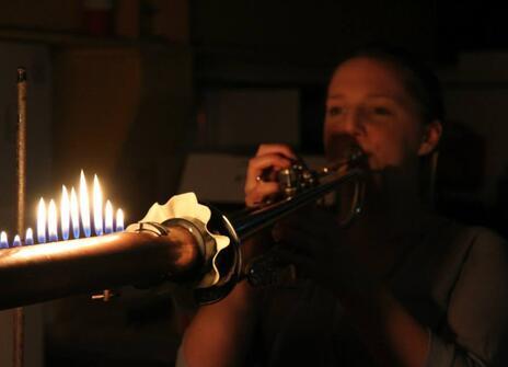 Anna plays a fire trumpet