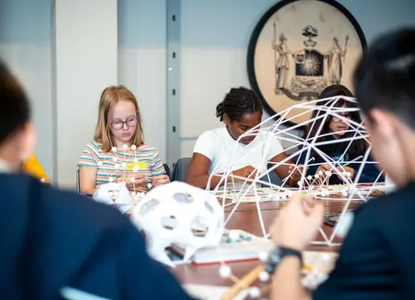 Participants sit building paper domes