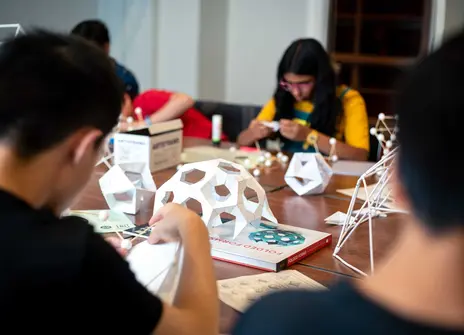 Participants sit building paper domes