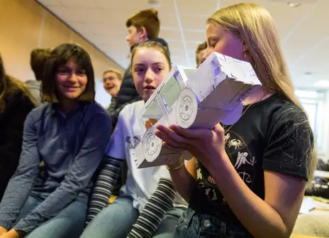 Participants holding a crash test model at a workshop