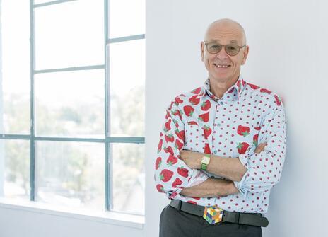 Dr Karl is his usual jazzy shirt, casually leaning against a wall