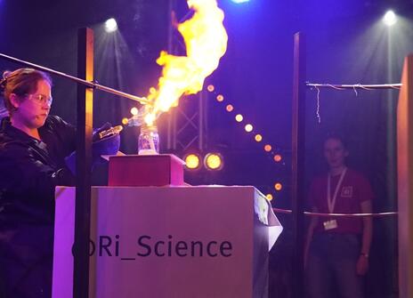 a person creates a fireball by blowing flamable gas through a flame