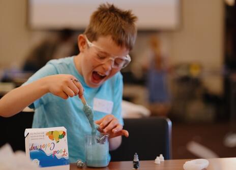a young boy is playing with blue slime