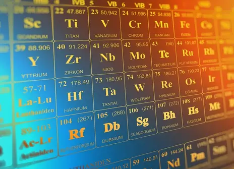 A close up of the element numbers on a periodic table. They're white and printed on a metallic background.