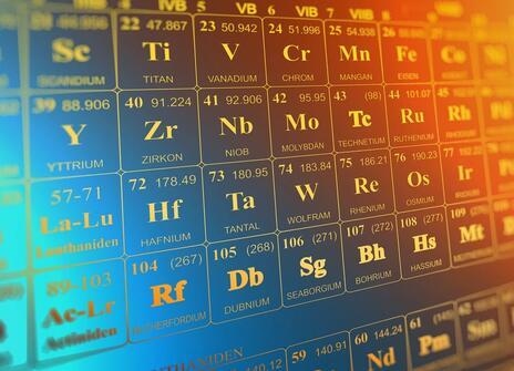 A close up of the element numbers on a periodic table. They're white and printed on a metallic background.