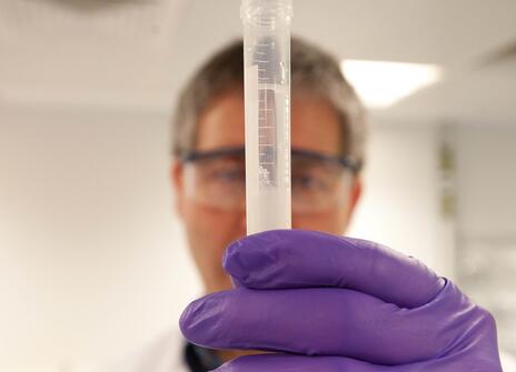 A person holds a tube filled with DNA
