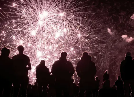 silhouettes of people watching a fireworks display