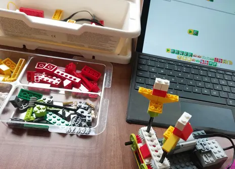 A LEGO creation made using the LEGO WeDo kit next to a laptop