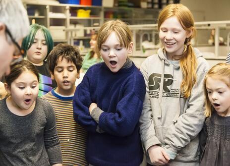 Children looking at something in awe in a computer science workshop