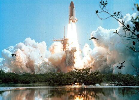 A rocket launching behind a lake