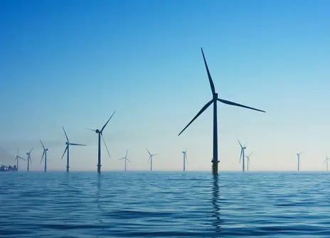 A picture of wind turbines out at sea. 