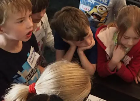 Young children overlooking a table