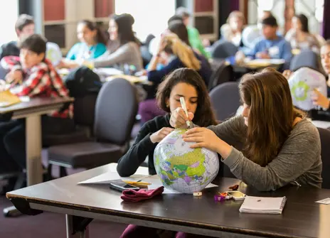 Children in a classroom with plastic globes