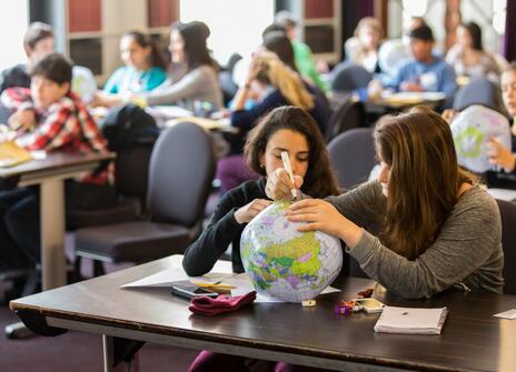 Children in a classroom with plastic globes