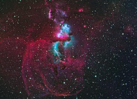 A pink and blue gas cloud floating in space. 