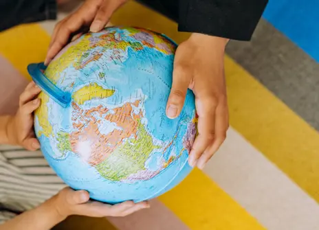 Two people holding a globe