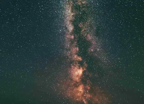The silhouette of three people looking up at the stars