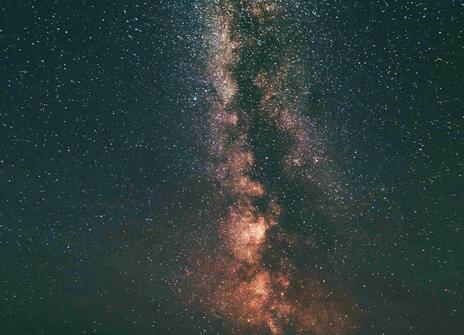 The silhouette of three people looking up at the stars