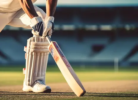 Close up of a cricketer holding a bat in a cricket ground.