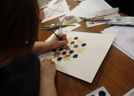 Young people drawing and painting Islamic geometric images