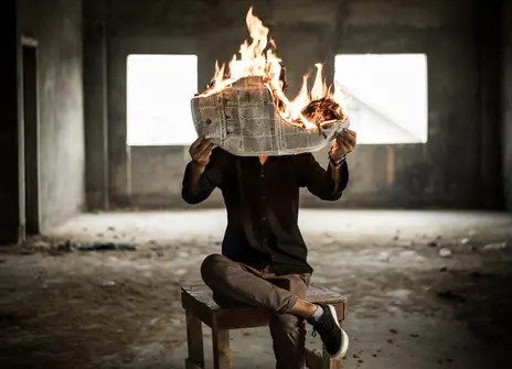 a man holding a newspaper on fire