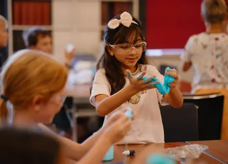 Students playing with molten blue plastic 