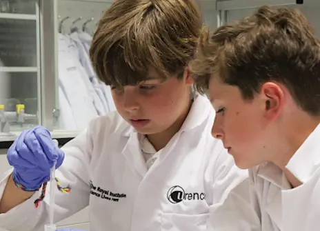 Participants at a workshop wearing lab coats