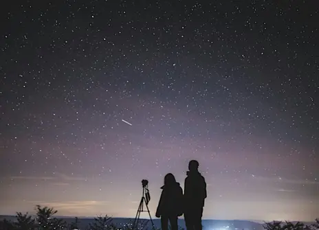 Two people against a backdrop of the starry night sky