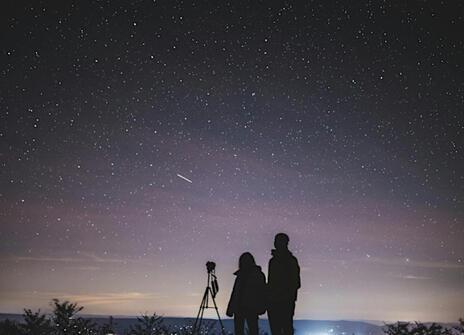 Two people against a backdrop of the starry night sky