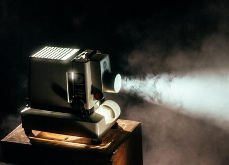 a black projector is on and a light is shining out of the front of it