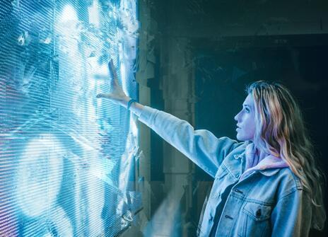 A women infront of a blue LED screen