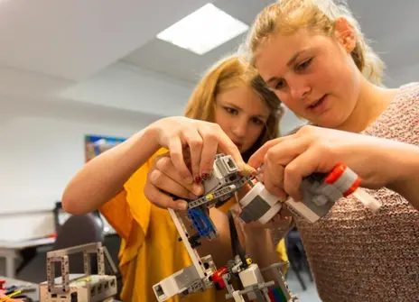 Participants working on a small LEGO Mars rover