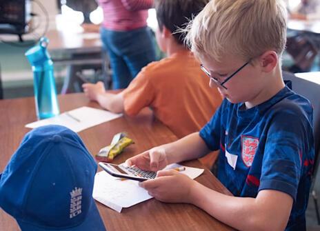 Blonde boy using a calculator