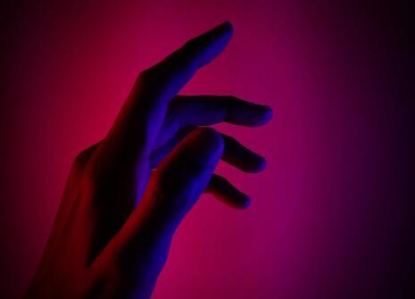 a shadow of a hand against a pink background