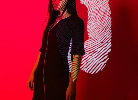 A women stand in front of fingerprint with red background 