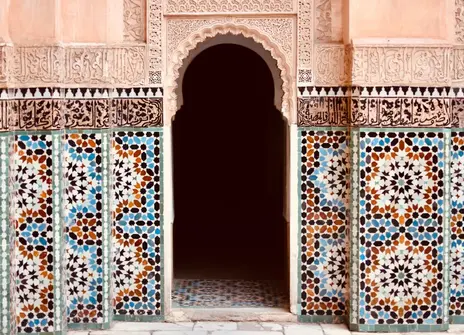 A arch shaped doorway surrounded by coloured tiles. 