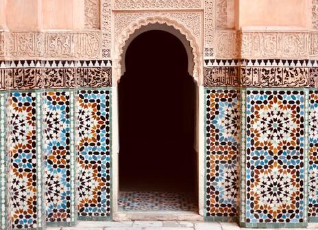 A arch shaped doorway surrounded by coloured tiles. 